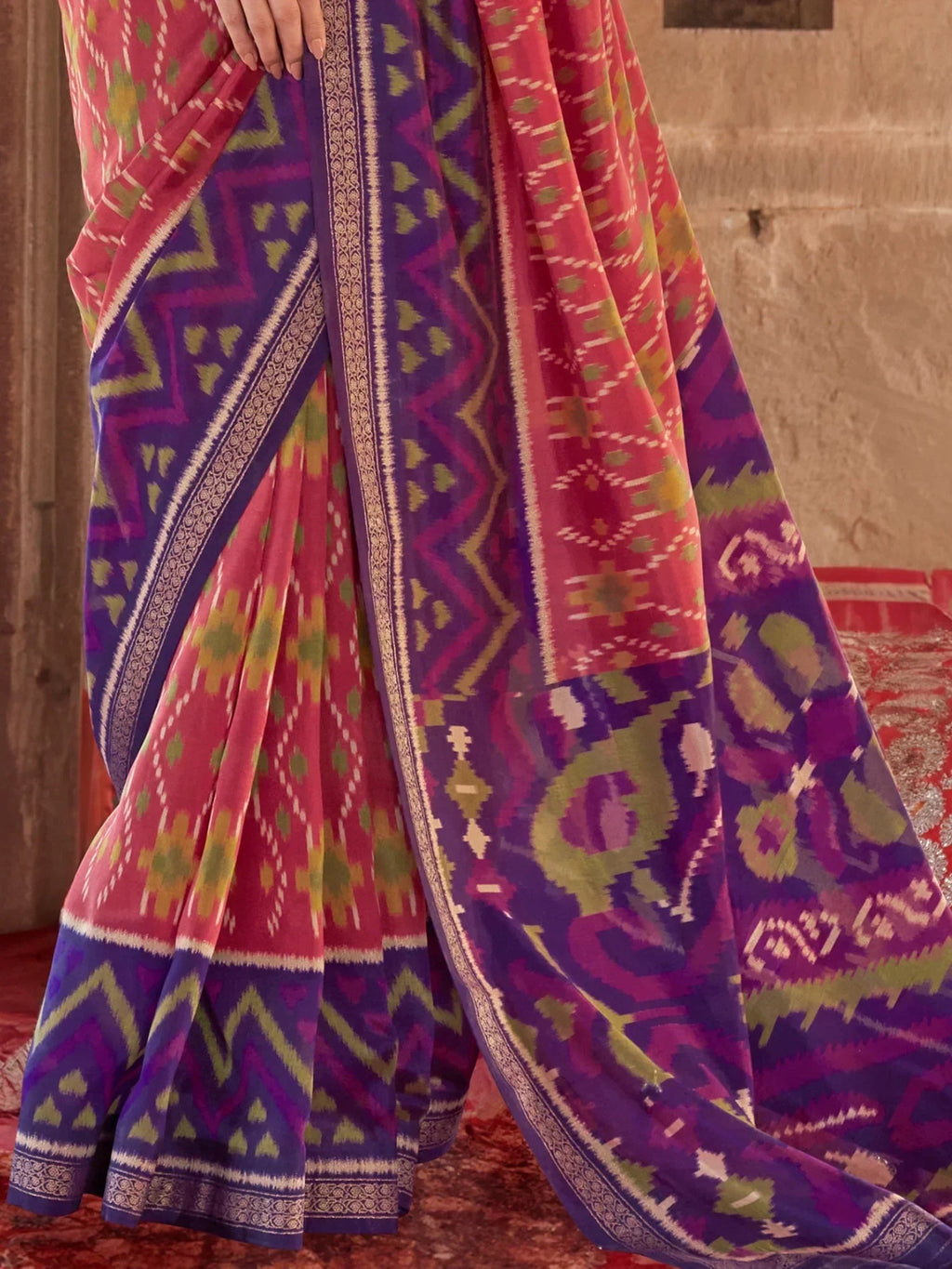 Bewitching Coral Red Patola Printed Georgette Saree With Purple Blouse